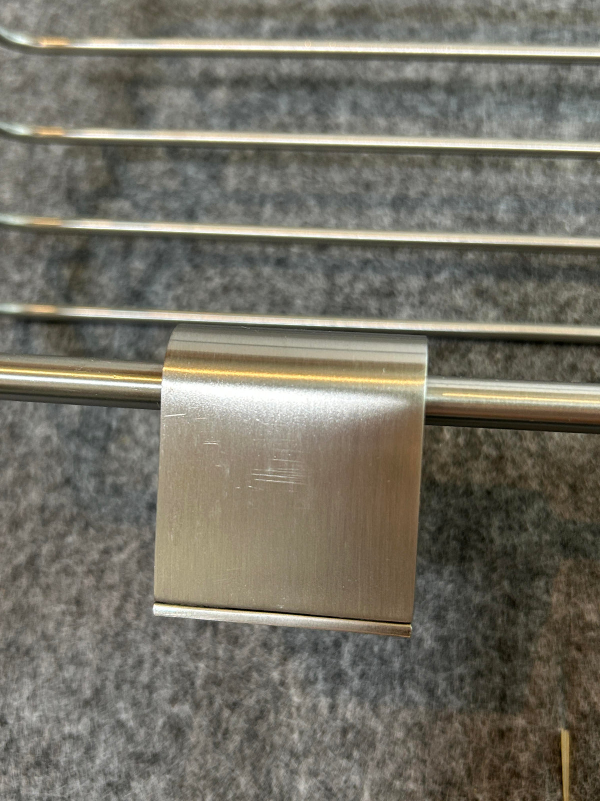 ZACK 40426Y：ATOREのシャワーバスケット：取付金具の銀色の表面と上側の縁が見える拡大