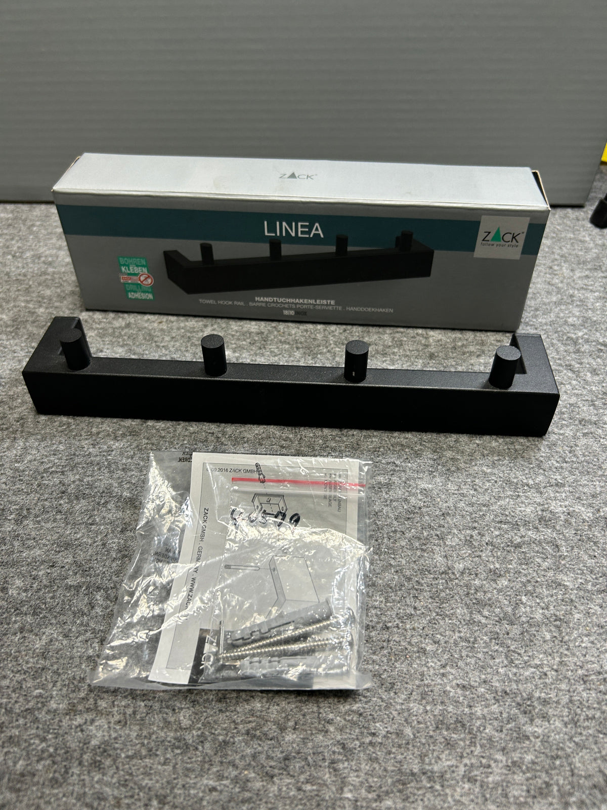 ZACK 40579Y タオル掛け：本体と取付部品、パッケージを並べた状態